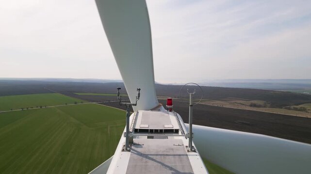 Aerial Close-up of Wind Turbine Nacelle and Blades Over Green Fields
