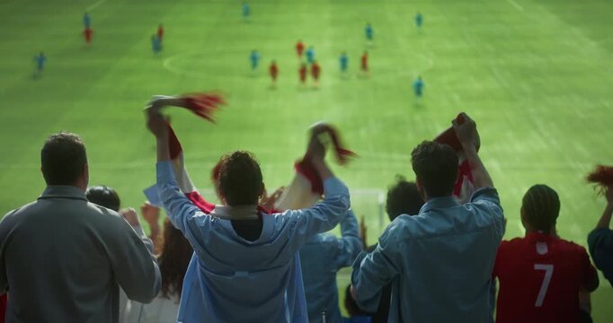 Rear View of Diverse Football Supporters in a Packed Stadium, Waving Scarves, Clapping and Raising Arms as a Professional International Championship Match Game Field