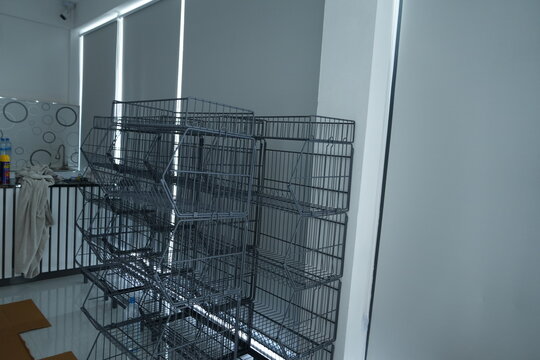 Empty black wire shelving units stacked in a modern room with white walls