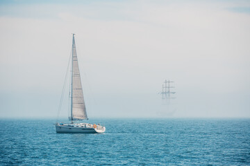 Sailboat With White Sails Sailing on a Calm Foggy Sea © ValentinValkov