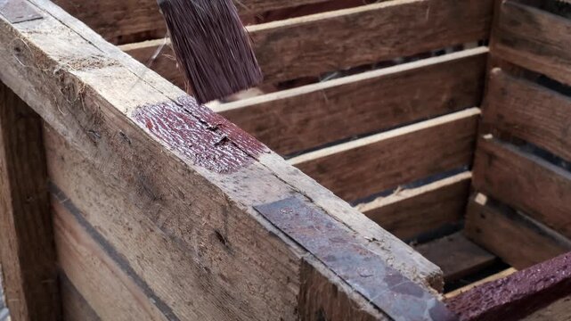 Hand Painting Wooden Crate With Brush Applying Protective Wood Stain
