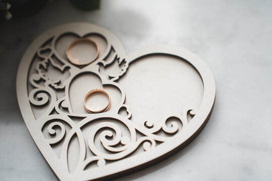 newlyweds wedding rings on a wooden heart-shaped stand