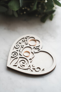 newlyweds wedding rings on a wooden heart-shaped stand