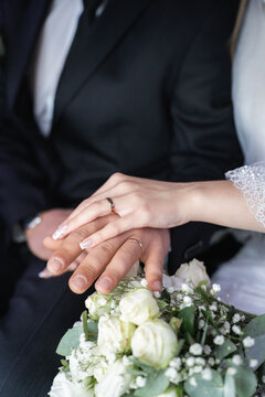 Couple's hands wearing engagement and wedding rings, symbolizing love, commitment, and marriage. A close-up view of joining hands