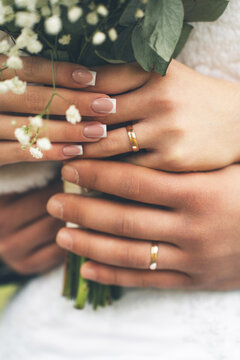 Couple's hands wearing engagement and wedding rings, symbolizing love, commitment, and marriage. A close-up view of joining hands