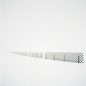 Fence line surrounded by snowcovered landscape below white sky, Frankenmarkt, Austria
