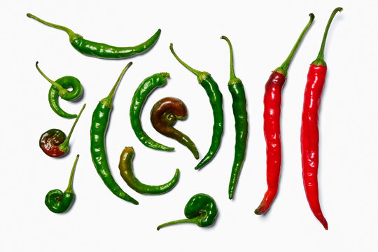 Flat lay still life of red and green chili peppers on a white background
