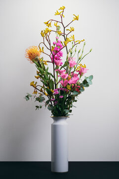 Beautiful bouquet of eucalyptus, hoary stock, protea, and kangaroo paw against a white background
