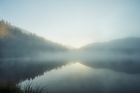 Ethereal fog over mountain lake surface at dawn, Lake Prebersee, Austria
