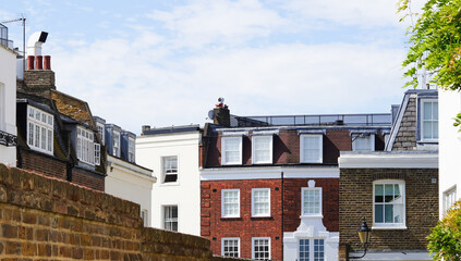 Obraz premium Residential buildings with brick walls and rooftops under blue sky
