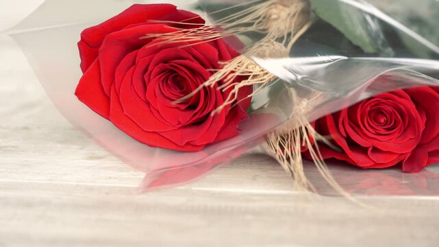 Red rose wheat cellophane wrap white wood surface macro horizontal sant jordi catalonia spain

