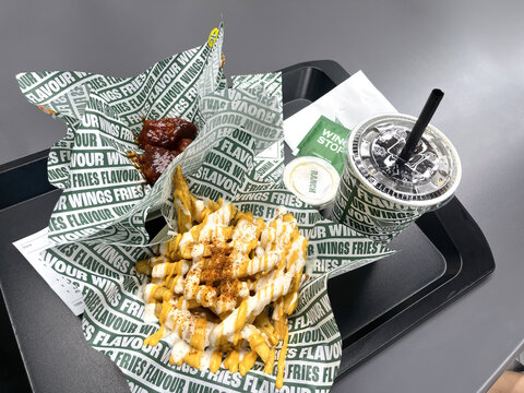 crispy French fries from Wingstop served on table tray featuring golden color and crunchy texture, perfect for fast food, snack, and casual dining concepts with appetizing presentation and Cola drink