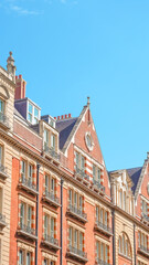 Fototapeta premium Historic brick buildings with ornate rooftops against a clear blue sky