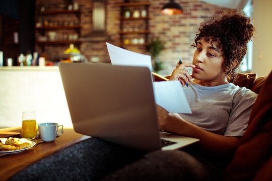 Woman reviewing bills on laptop at home