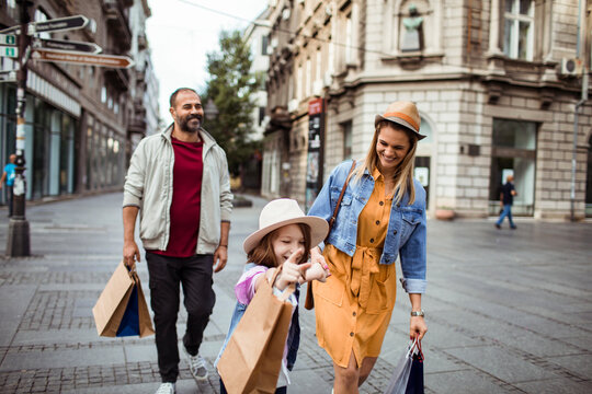 Happy family shopping together on city street