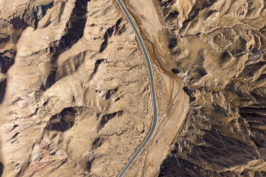Aerial view of a road winding through the colorful Danxia landform mountains in Qilian, China