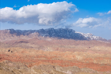 Naklejka premium The unique Danxia landform of China's Qilian Mountains under a bright blue sky with white clouds