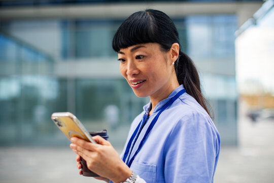 Professional woman using smartphone outside office building