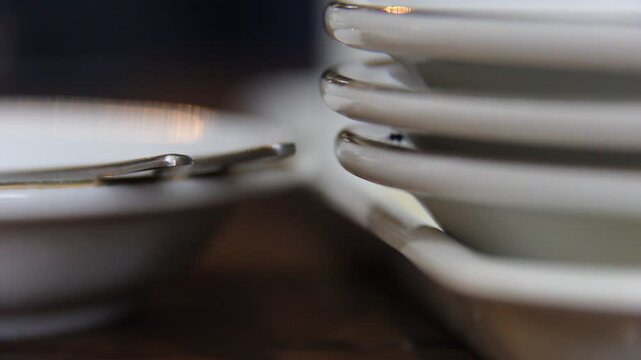 Ant moving between stacked white plates in a minimal kitchen scene. Ideal for hygiene, pest control, or food safety concepts.