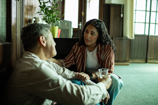 Counselor comforting man at group therapy meeting in community center