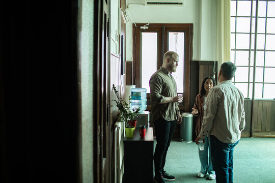 Adults in group therapy discussion at community center hallway