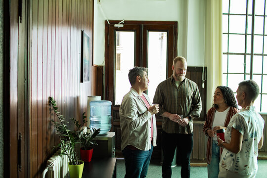 Diverse adults talking during group therapy break at community center