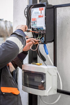 Energy Meter Installation. Electrician Installing an Tree-phase Electricity Meter.