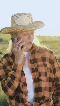Farmer and businesswoman talking mobile phone, working in wheat field, making deal, using smartphone. Agricultural business concept. Growing food. Companions, work colleagues. Wheat field. Slow motion