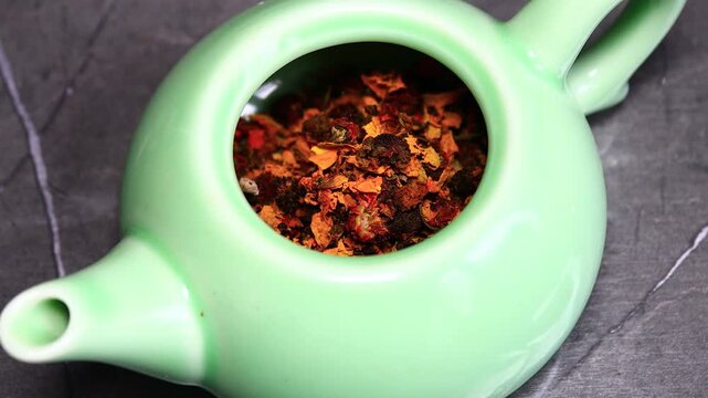 A green tea pot filled with a mixture of food, perfect for serving small dishes