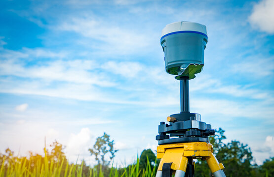 GPS surveying equipment on blue sky and white clouds background. GPS, GIS, and GNSS equipment. Land survey for map. Technology for marks land to made satellite map on the earth. Smart GNSS,GPS survey.
