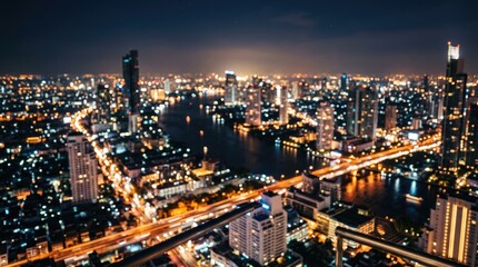 Fototapeta premium Nighttime aerial view of illuminated urban cityscape with highways.