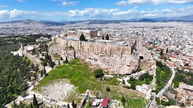 Aerial drone cinematic video of iconic Acropolis hill and the Parthenon a true ancient monument of Western Civilization with beautiful clouds, Athens historic center, Attica, Greece