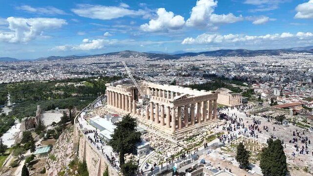 Aerial drone cinematic video of iconic Acropolis hill and the Parthenon a true ancient monument of Western Civilization with beautiful clouds, Athens historic center, Attica, Greece