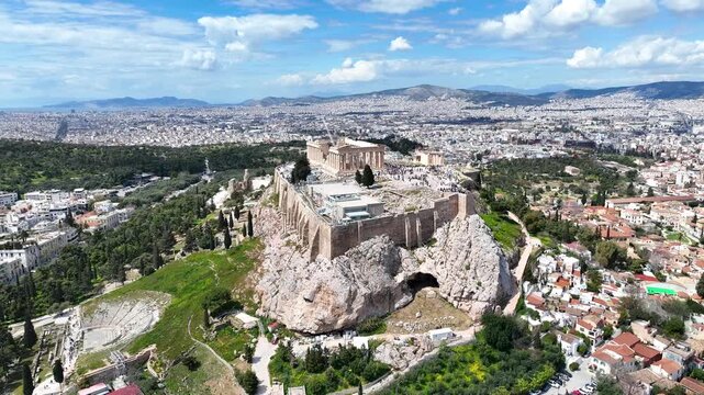 Aerial drone cinematic video of iconic Acropolis hill and the Parthenon a true ancient monument of Western Civilization with beautiful clouds, Athens historic center, Attica, Greece