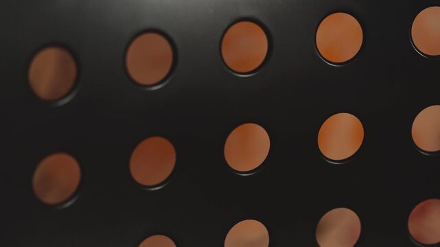 A close-up shot of a black and orange polka dot pattern, ideal for use in designs where bold graphics are needed