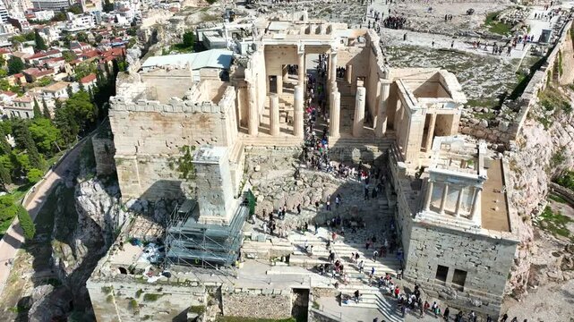 Aerial drone cinematic video of iconic Propylea or gate of Acropolis hill and the Parthenon, Athens historic centre, Attica, Greece