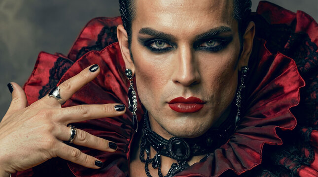 Professional close up of a male drag queen in traditional red and black flamenco costume with ruffles, intense makeup, gothic jewelry and bold red lips, closeup