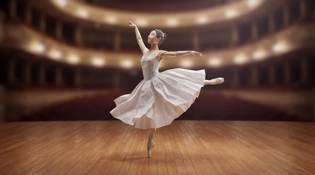 Origami paper ballerina dancing on a wooden stage. Handmade folded paper sculpture of a ballet dancer with a blurred theater auditorium background