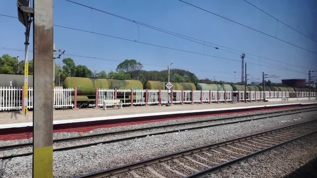 POV from moving train passing railway tracks and freight tanker wagons, travel and transport concept