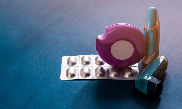 Set of asthma inhaler accuhaler and anti allergy pills on blue table, medical treatment for respiratory disease. Bronchodilator and steroid drugs for severe asthma control and relief in healthcare.