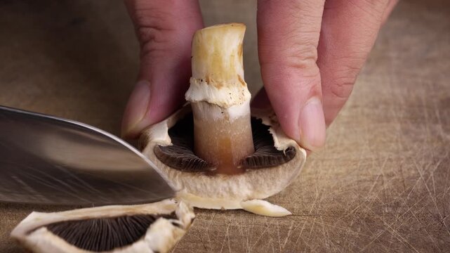 Macro Slicing Champignon Mushroom on Wooden Table with Knife Food Preparation Close Up