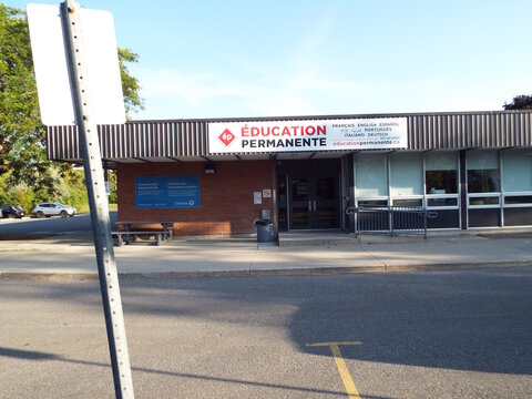 Vanier, Ontario, Canada &ndash; July 25, 2025: The "&Eacute;ducation Permanente" building features a multi-language sign, a red brick exterior, and a School Facility Renewal Project notice at 181 Donald St.