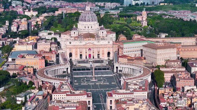 Aerial view of St. Peter&rsquo;s Basilica and St. Peter&rsquo;s Square in Vatican City, showing the iconic dome, Bernini colonnades, and surrounding Rome cityscape in daylight.