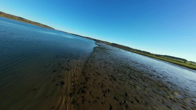 FPV drone orbit of beached yacht on Orwell River strand UK