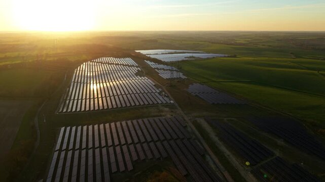 Aerial drone view of Tye Lane solar farm at golden sunset with renewable energy arrays in Suffolk UK