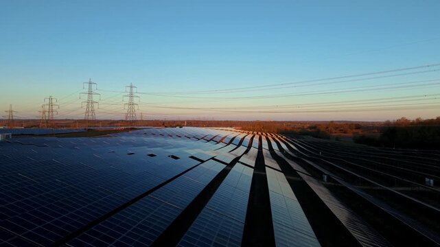 Aerial drone view of Tye Lane solar farm at golden sunset with renewable energy arrays in Suffolk UK