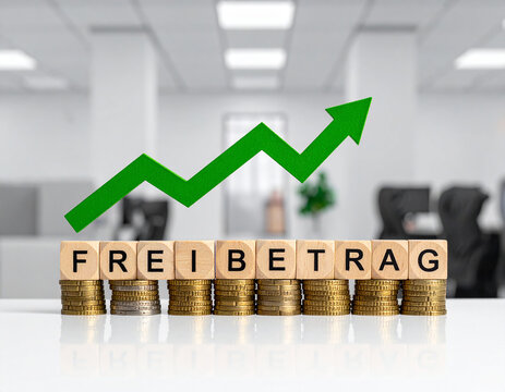 Holzklötze bilden das Wort "Freibetrag" auf Münzstapel , mit einen steigenden grünen Pfeil.