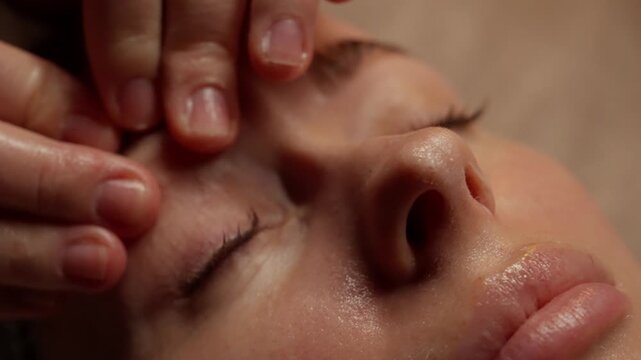 Close-up facial massage therapy sequence showing gentle fingertip pressure around eyes and forehead, highlighting relaxation, skincare, and soothing spa treatment