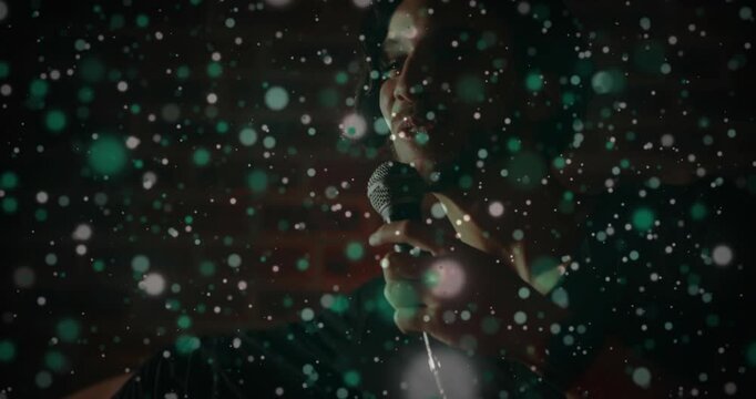 Floating bokeh drifting aside, male singer shifting forward, lifting mic and performing song