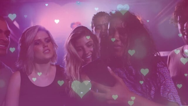 Person raising smartphone sharing content at concert, friends leaning, heart overlay bathing group